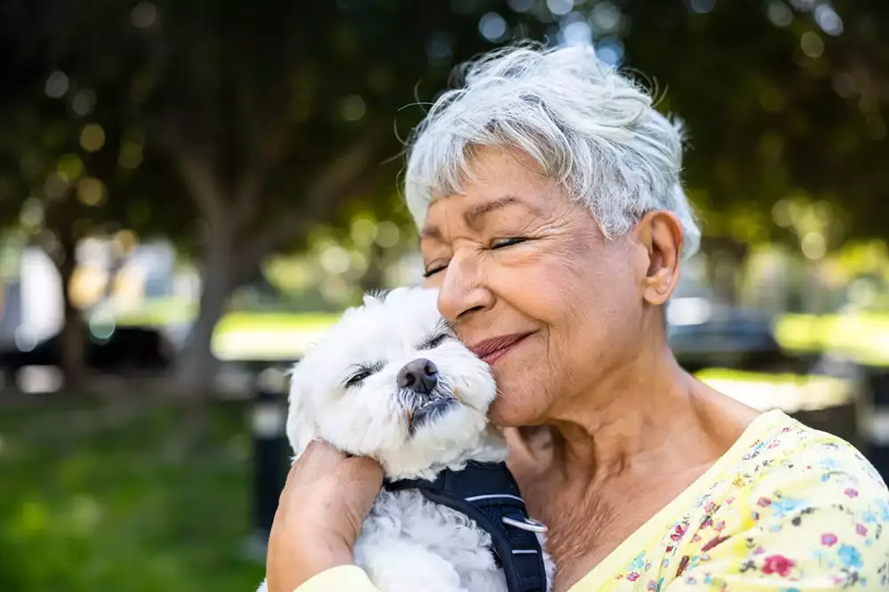 Senior woman cuddling with her dog